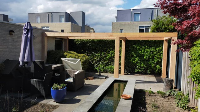 Plaatsen van Douglas pergola met betonpoeren.