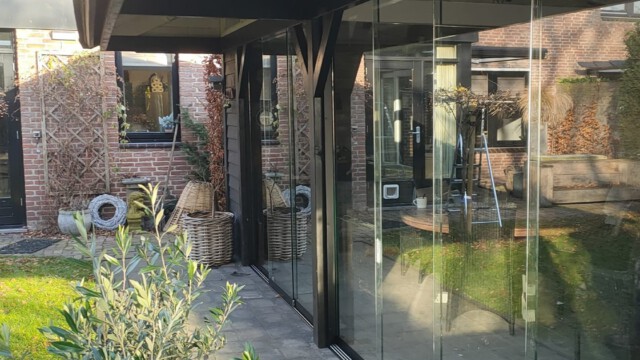 Deze overkapping hebben wij voorzien van een glazen schuifpui met daarboven en aan de zijkant een kozijn met vastglas.