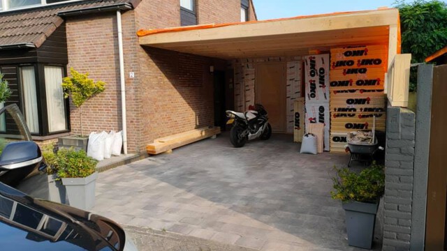 Renovatie van aanbouw. Hierbij hebben we de oude aanbouw afgebroken en de ruwbouw van de nieuwe aanbouw met overkapping en carpoort geplaatst. In de achtergevel hebben we het kozijn vervangen voor een nieuwe grote schuifpui en een doorbraak gemaakt naar de bestaande woning.